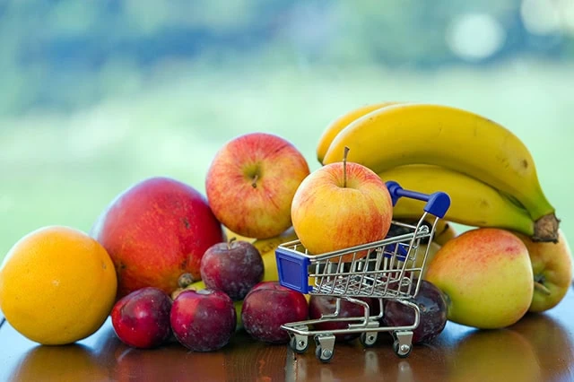 4 Best Consumer Staples ETFs You Can Buy 7 several different fruits, including a single apple filling up a tiny shopping cart.