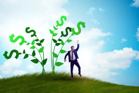 a businessman reaches for the tops of vines with dollar signs at the top.