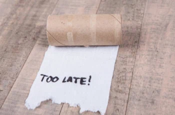 Toilet paper rolls out of paper with message isolated on a wood background